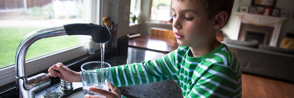 A child pours tap water into a glass