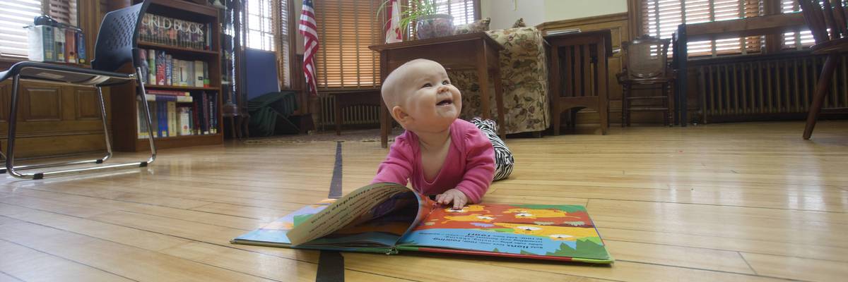 A child reads a book on the border at the Haskell Free Library.