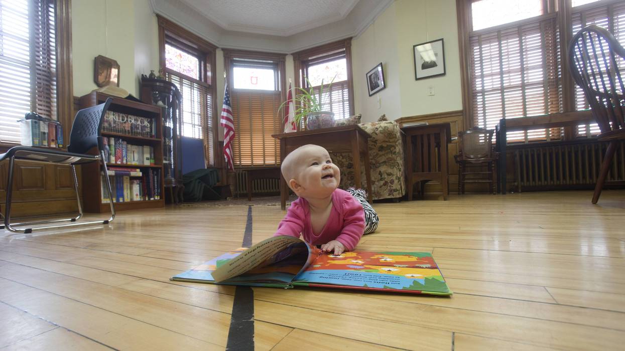 A child reads a book on the border at the Haskell Free Library.