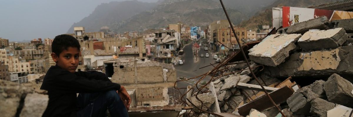 A child sits in the rubble of his ruined home in Taiz, Yemen in 2016.