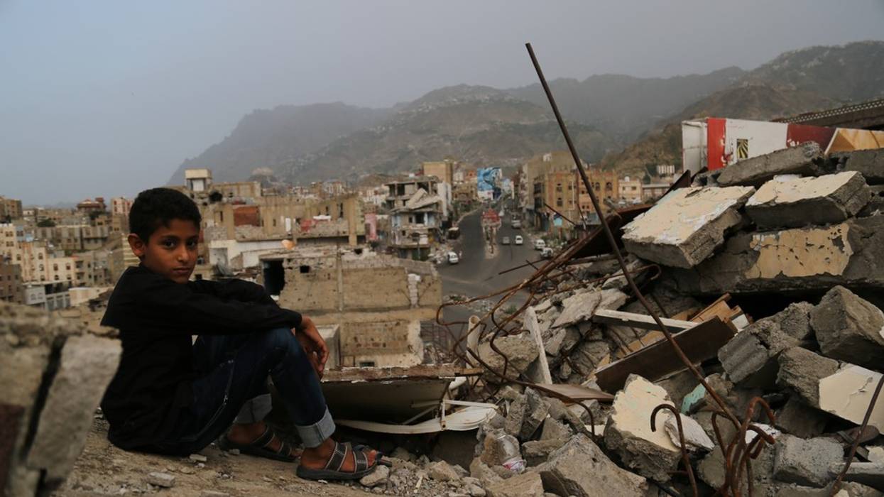 A child sits in the rubble of his ruined home in Taiz, Yemen in 2016.