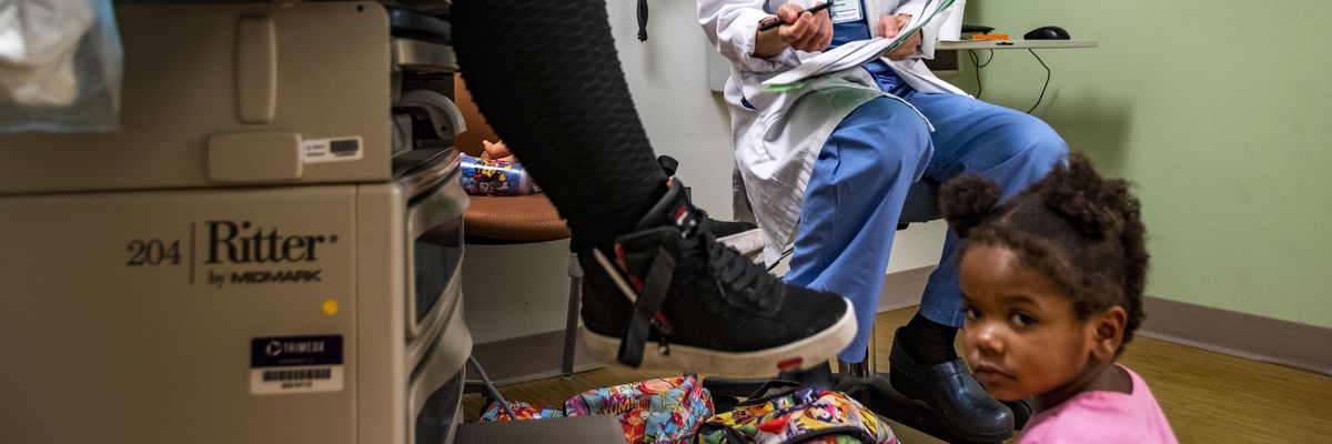 A child sits on the floor during a doctor's appointment