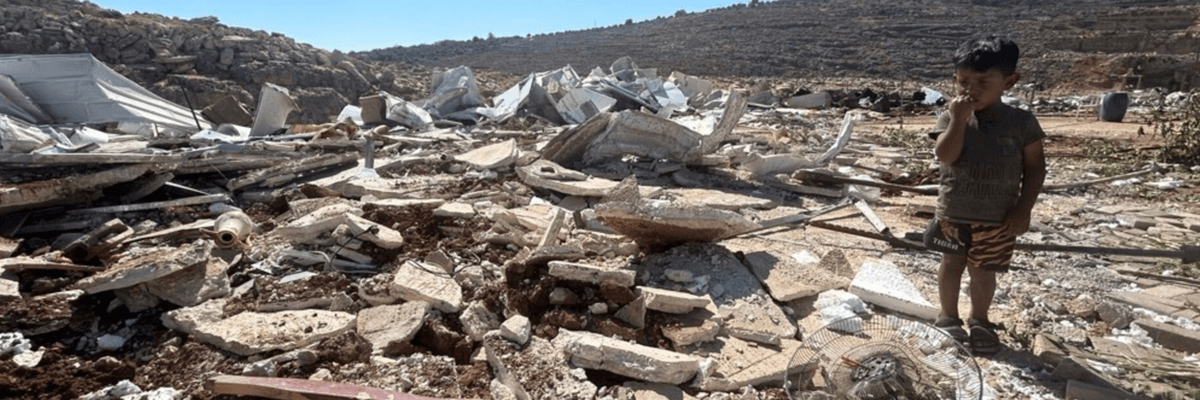 A child stands among the rubble after Israeli authorities demolished his family's home