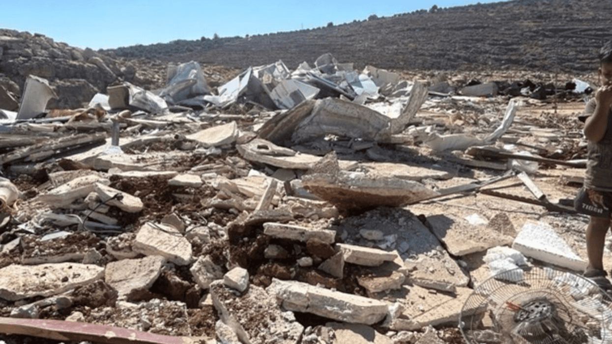 A child stands among the rubble after Israeli authorities demolished his family's home