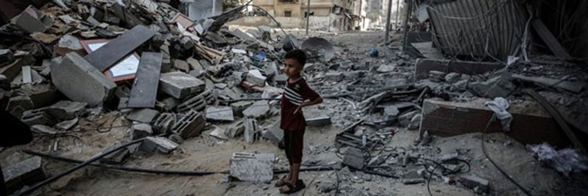 A child stands in rubble.