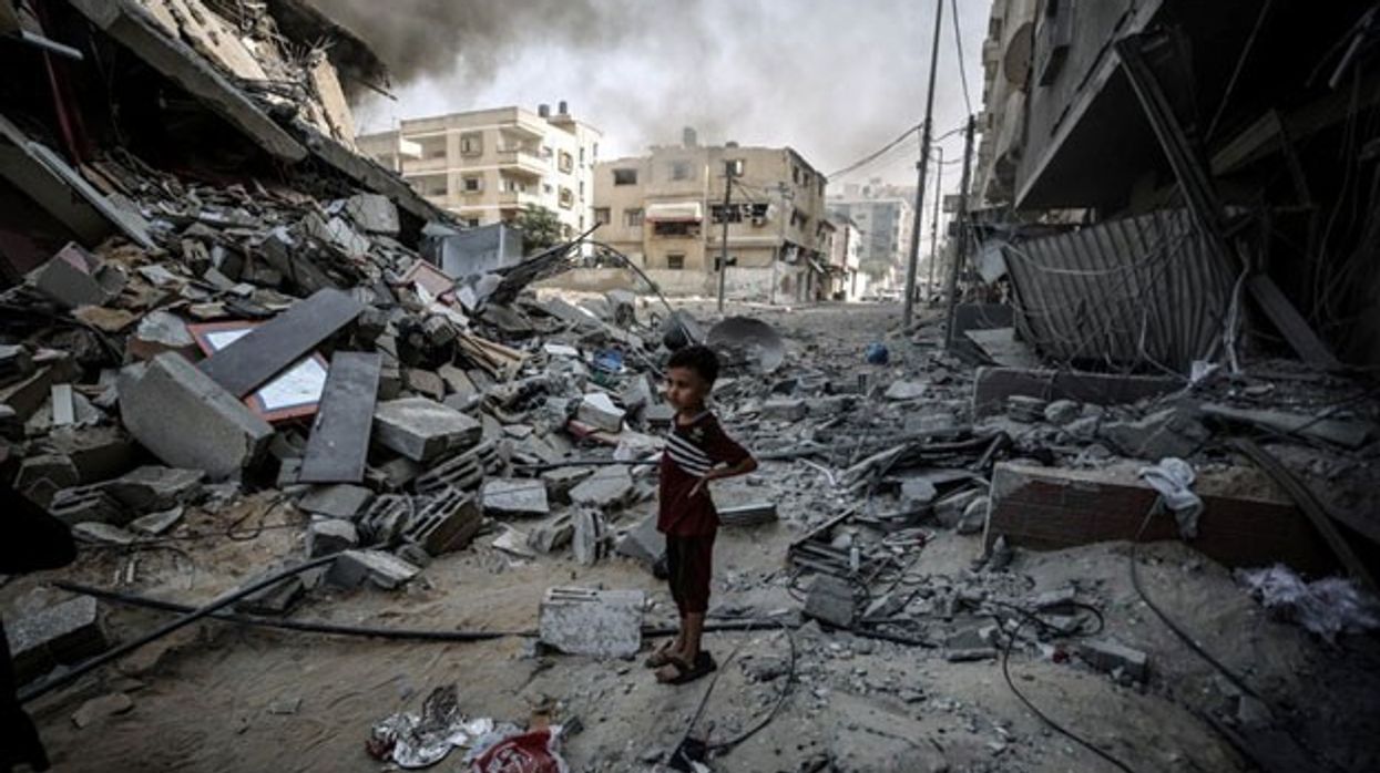 A child stands in rubble.