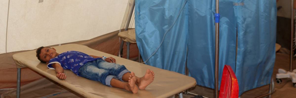 A child with cholera lies on a mat in a clinic in Yemen.