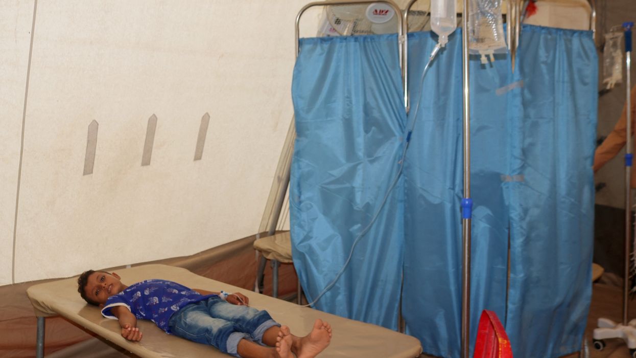 A child with cholera lies on a mat in a clinic in Yemen.