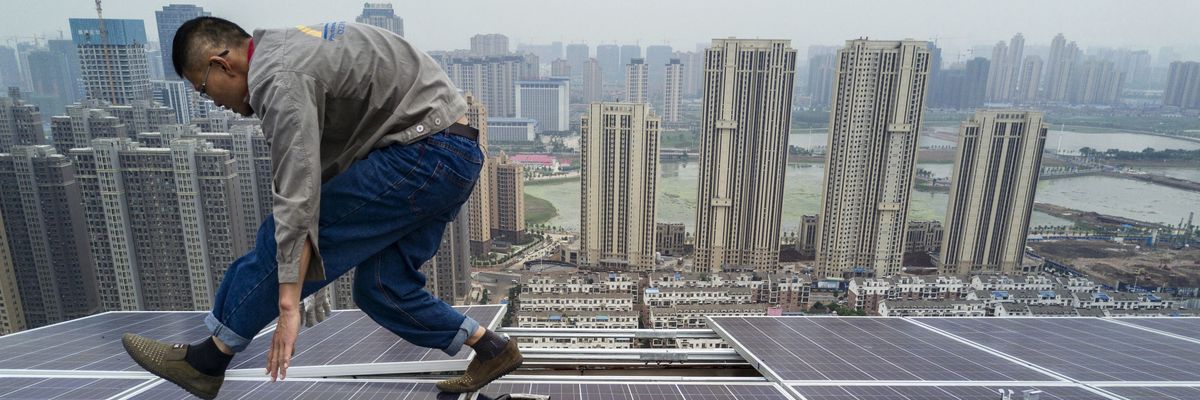 A Chinese worker works on solar panels.