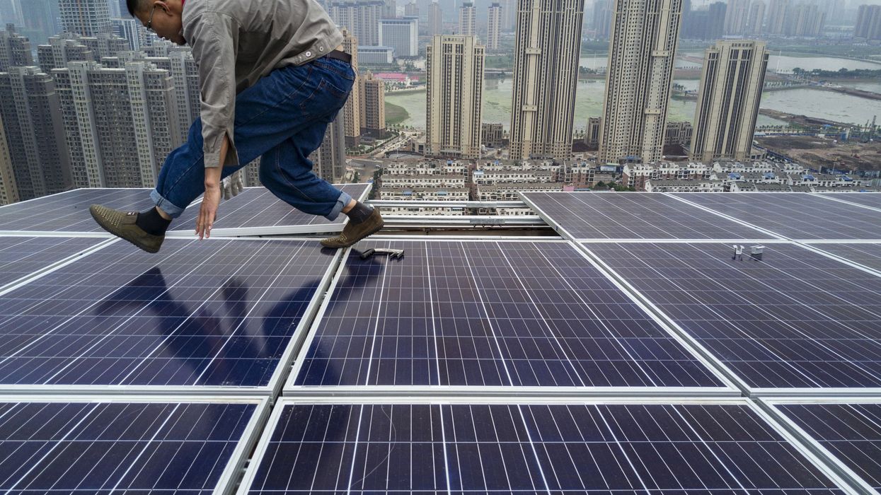 A Chinese worker works on solar panels.