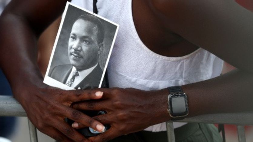 A civil rights supporter holds a photo of Martin Luther King Jr. at the 60th commemoration of the March on Washington