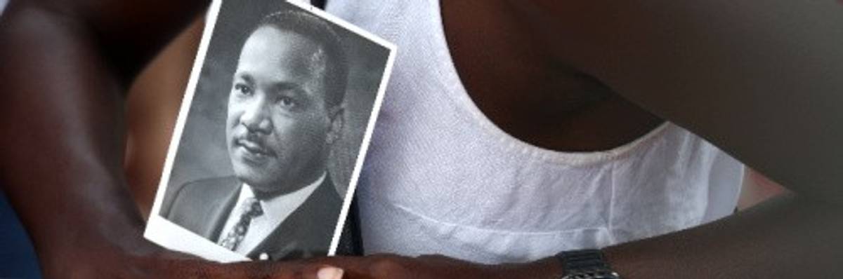 A civil rights supporter holds a photo of Martin Luther King Jr. at the 60th commemoration of the March on Washington