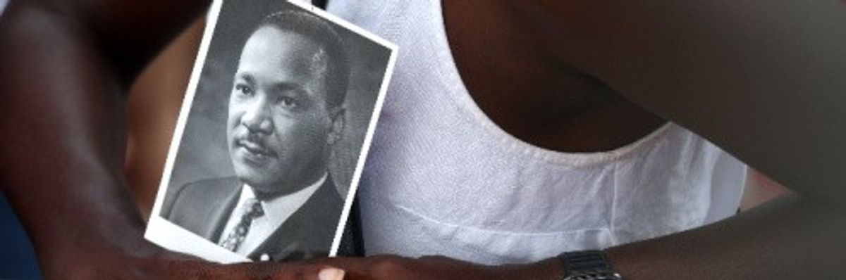 A civil rights supporter holds a photo of Martin Luther King Jr. at the 60th commemoration of the March on Washington