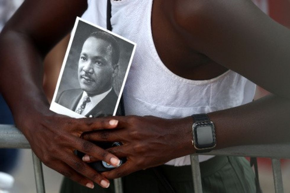 A civil rights supporter holds a photo of Martin Luther King Jr. at the 60th commemoration of the March on Washington