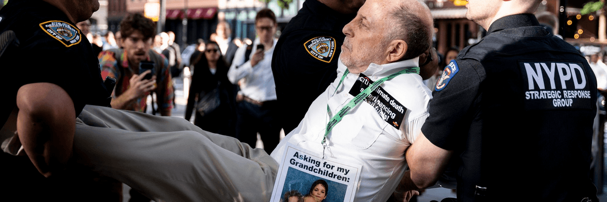 A climate campaigner is carried away by New York City police at a protest