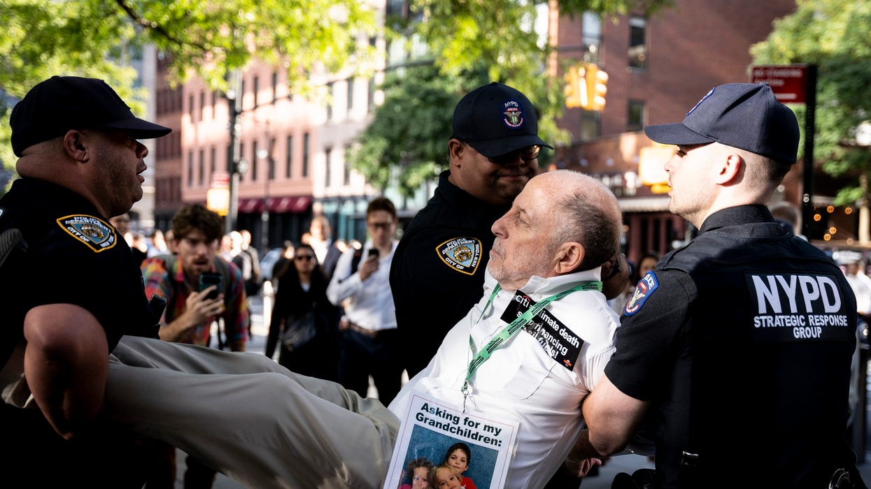 A climate campaigner is carried away by New York City police at a protest