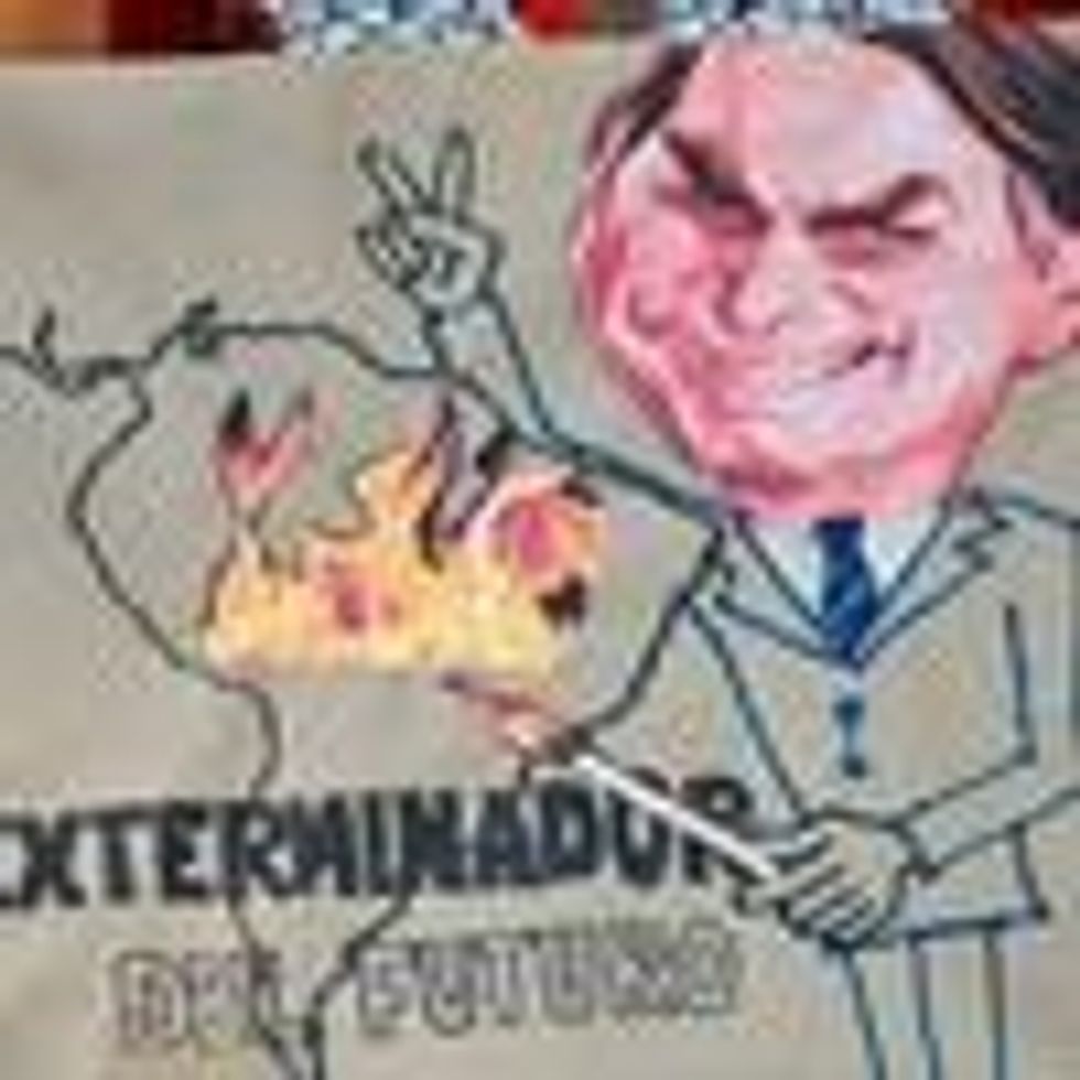 A climate change activist holds a sign depicting Brazilian President Jair Bolsonaro with the slogan