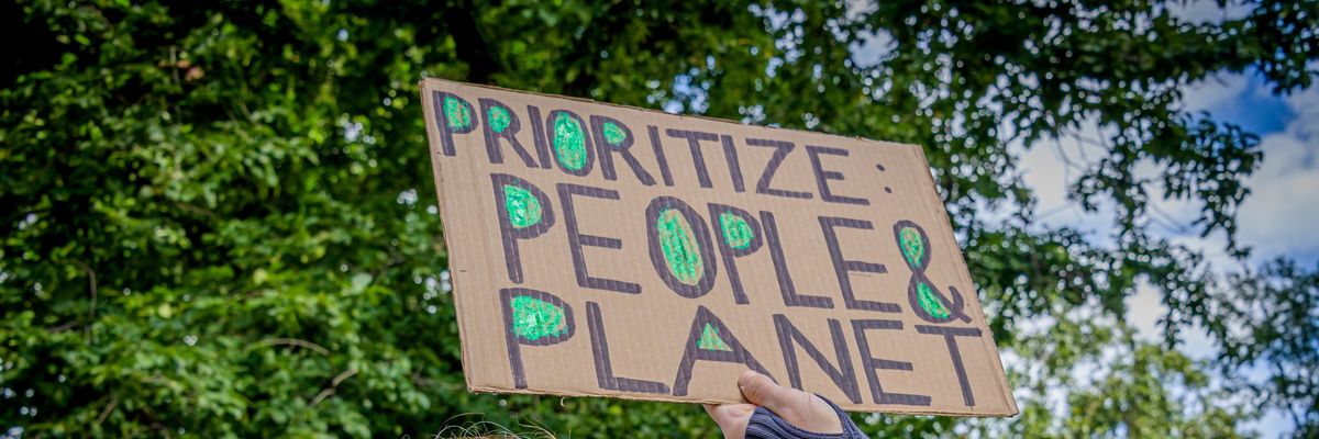 A climate marcher carries a sign that says "Prioritize: People & Planet" in New York City on September 20, 2020. ​