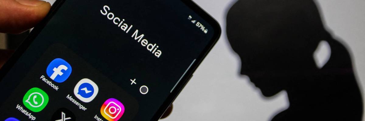 A close-up image of a hand holding a smartphone displaying social media applications
