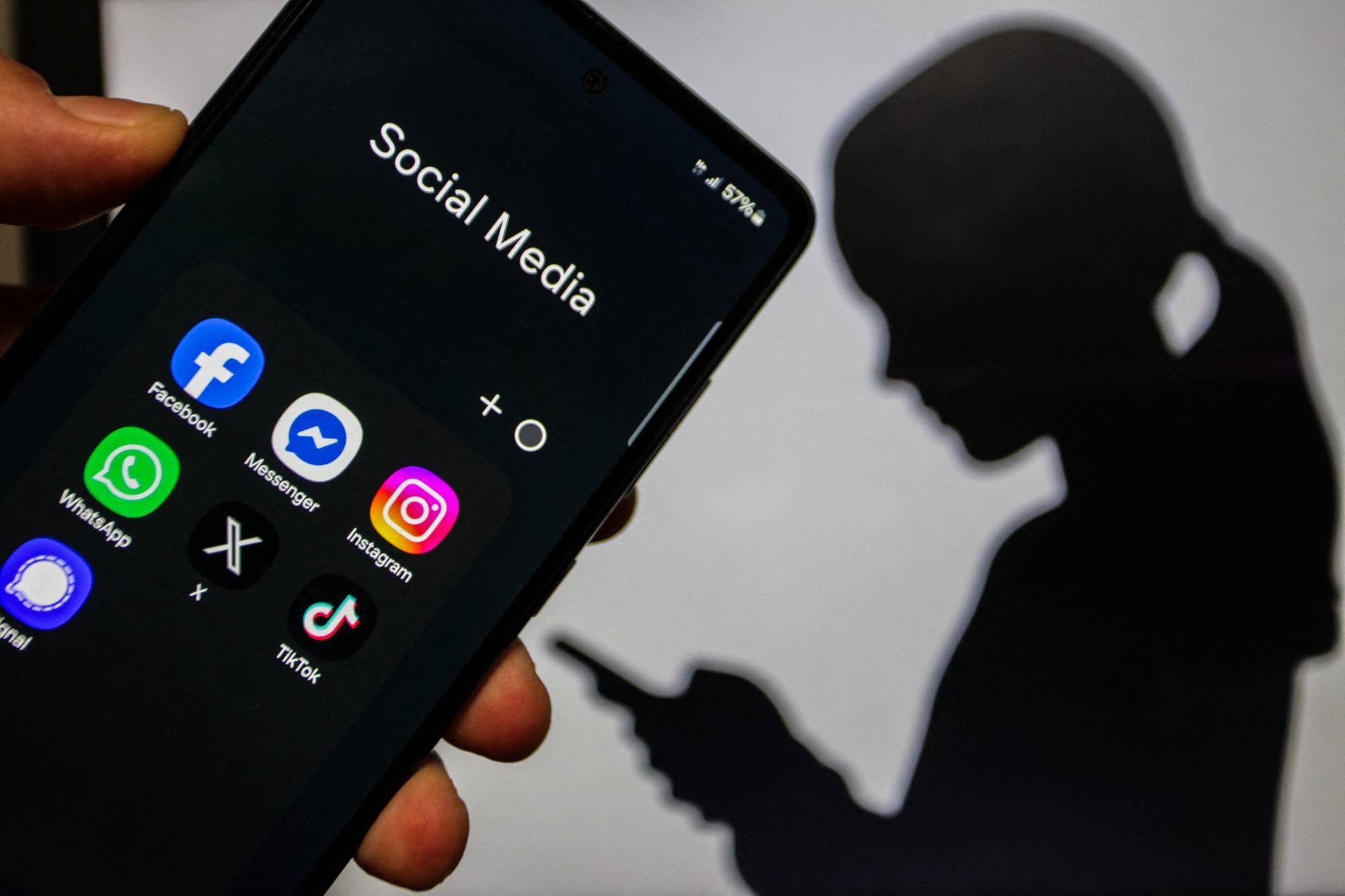 A close-up image of a hand holding a smartphone displaying social media applications