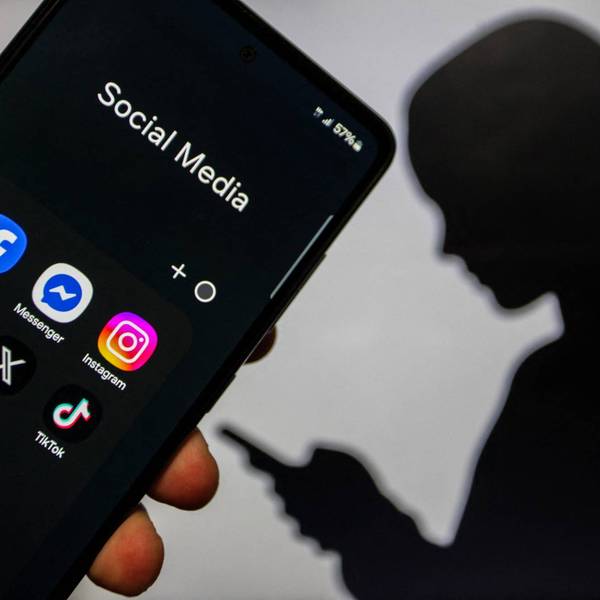 A close-up image of a hand holding a smartphone displaying social media applications