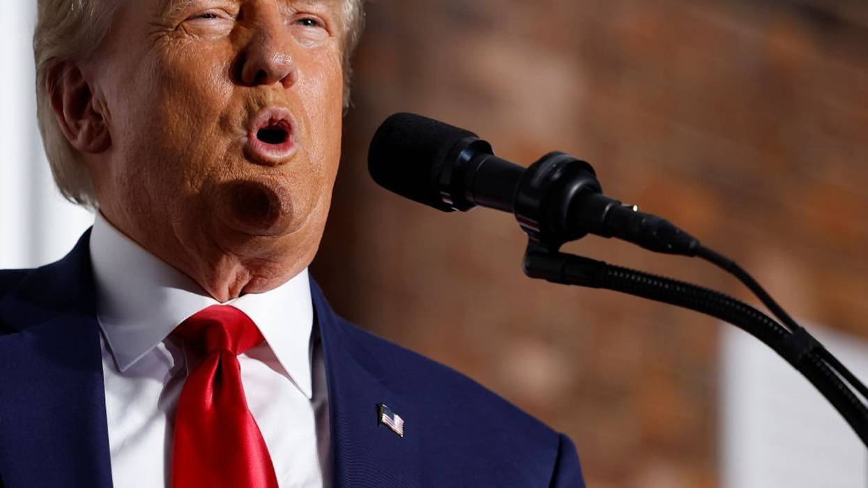 A close-up of Donald Trump speaking into a microphone.