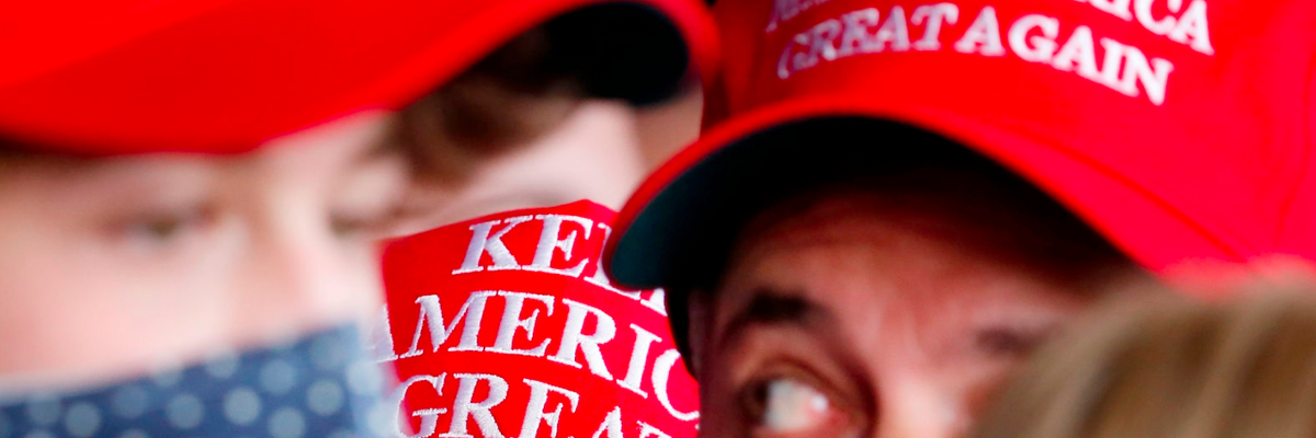 A close-up of people in MAGA hats.