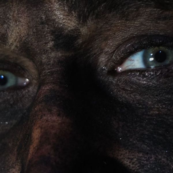 A coal miner's face is covered in dust