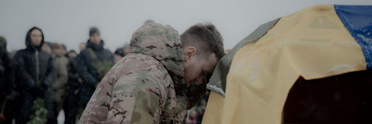 A comrade mourns next to the coffin containing the body of Anton Spitsyn