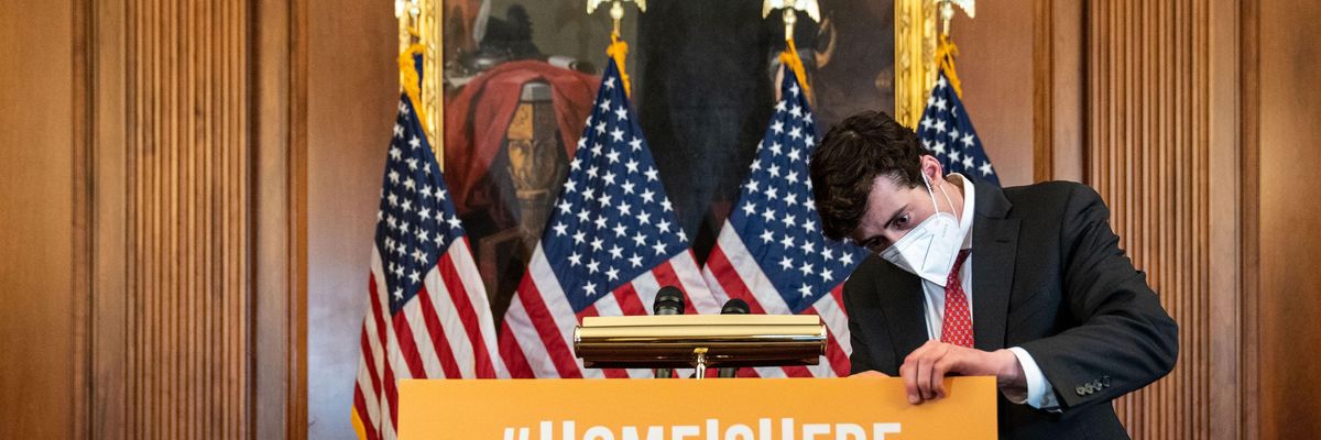 A congressional staffer adjusts a sign before the start of a press conference