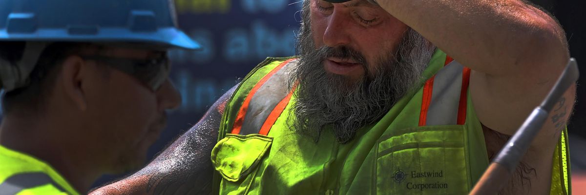 A construction worker takes his hard hat off