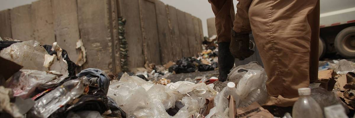 A contract worker finds recycling at a dump on an Iraq US military base.