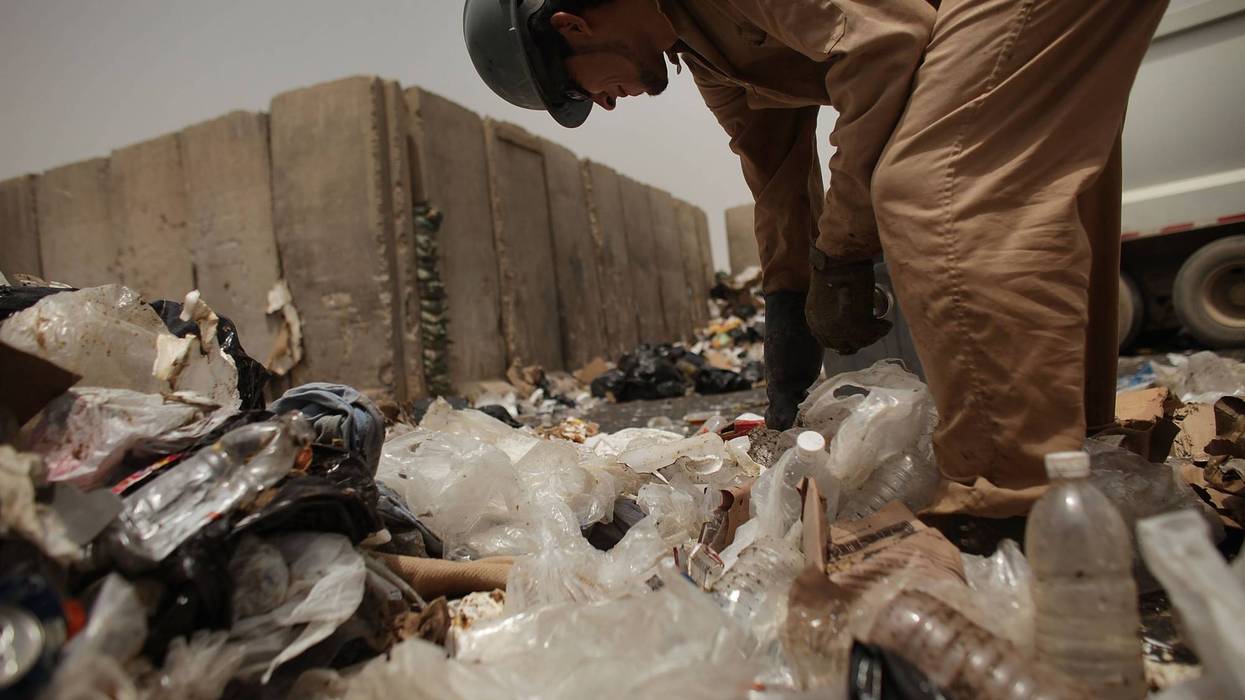 A contract worker finds recycling at a dump on an Iraq US military base.