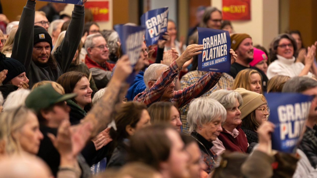 A crowd holds up "Graham Platner for US Senate" signs