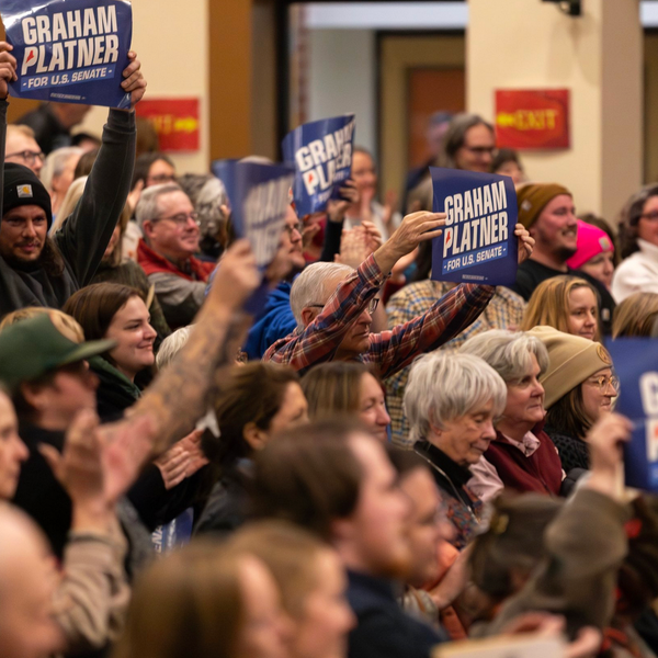 A crowd holds up "Graham Platner for US Senate" signs