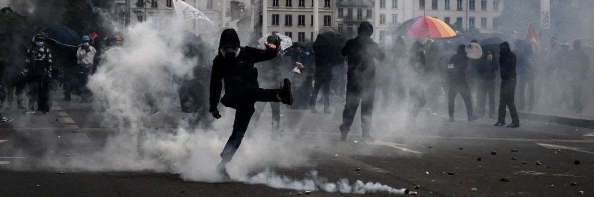 A crowd moves through teargas.