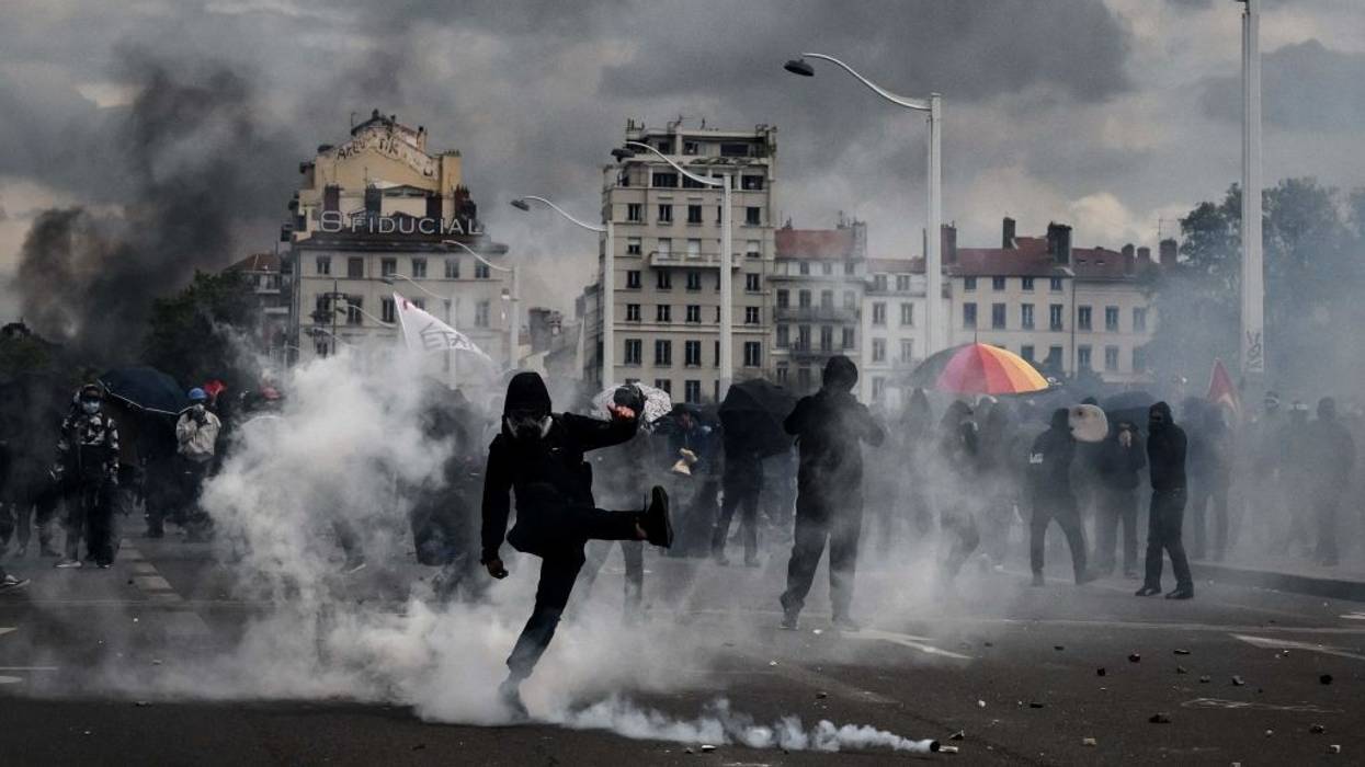 A crowd moves through teargas.