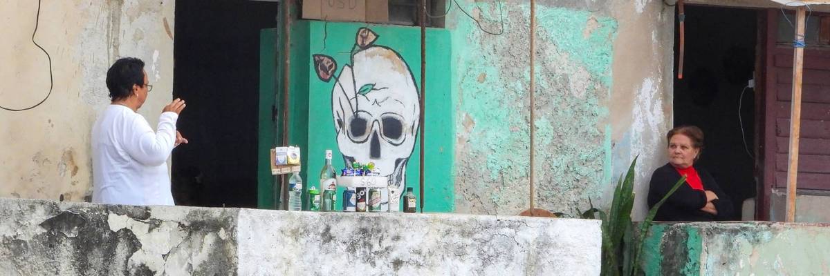 A Cuban woman sells drinks outside her home.