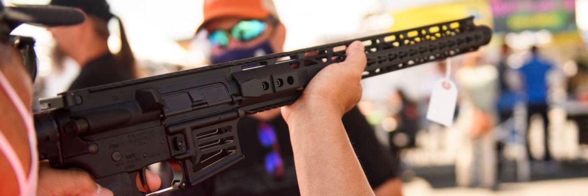 A customer holds an TPM Arms LLC California-legal featureless AR-15 style rifle