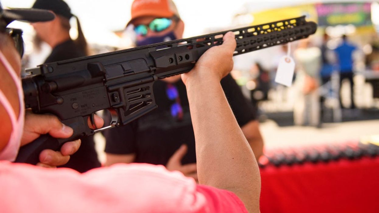 A customer holds an TPM Arms LLC California-legal featureless AR-15 style rifle