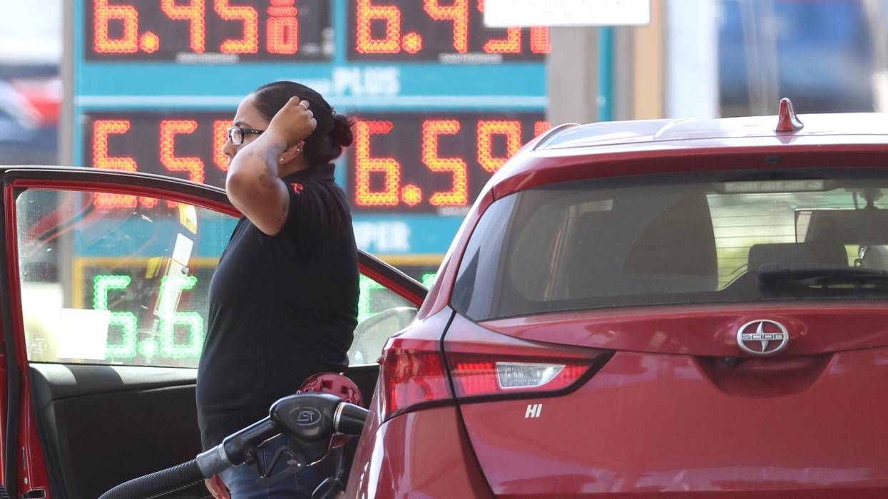 A customer refuels their car amid high gas prices.