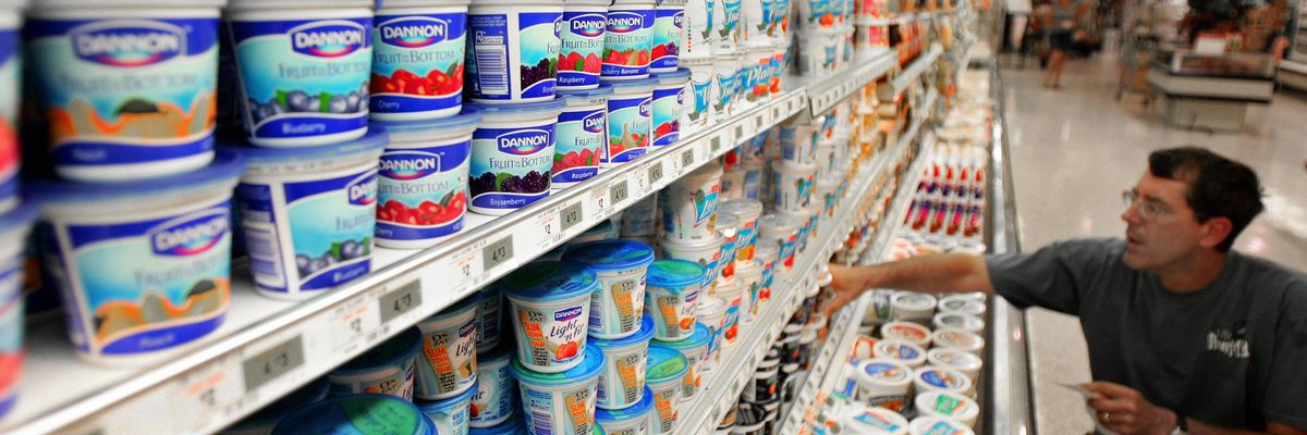 A customer selects Dannon yogurt from a dairy shelf at a Centreville, Virginia supermarket.