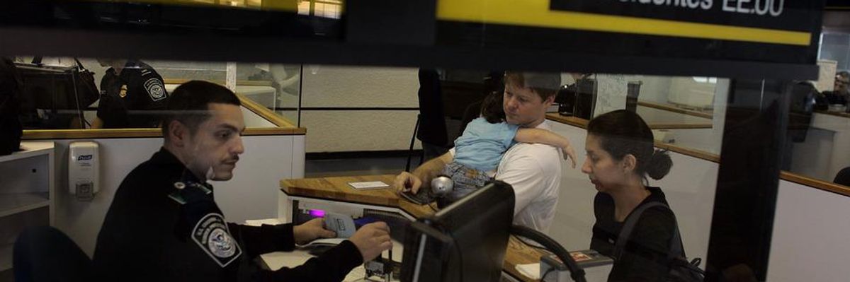 A Customs and Border Protection officer checks travelers in at the passport control area