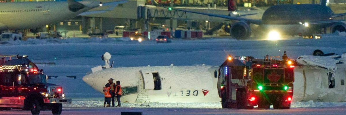 A Delta plane lies upside down on a runway at Toronto's airport after a crash