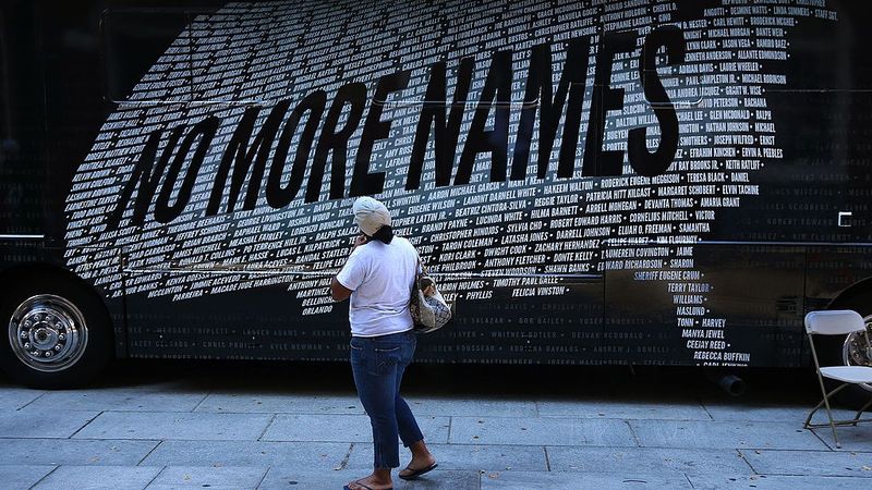 A demonstrater reads names of those killed by gun violence that form a U.S. map.