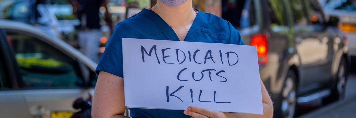 A demonstrator holds a "Medicaid Cuts Kill" sign at a rally