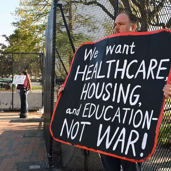 A demonstrator holds a placard in front of the White House