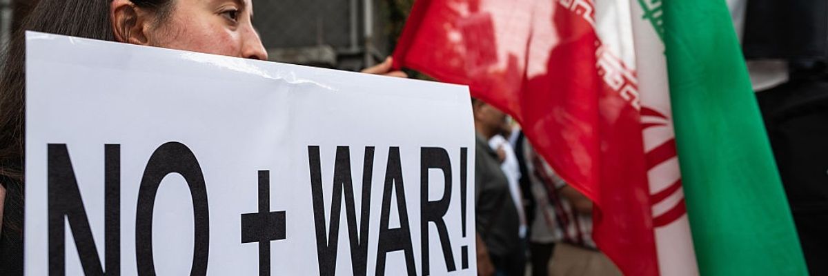 A demonstrator holds a placard opposing war with Iran