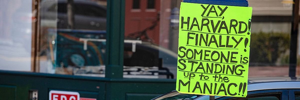 A demonstrator holds a sign after a rally against U.S. President Donald Trump's attacks on Harvard
