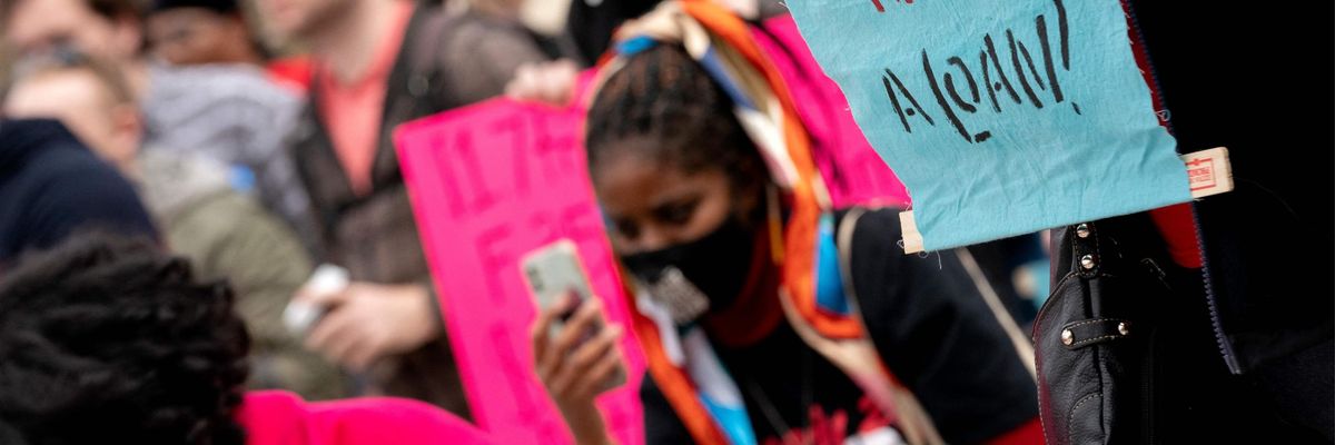 A demonstrator holds a sign during a student debt cancellation rally